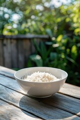 Poster - rice in a bowl in a white bowl on a wooden table. Selective focus