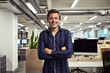 © NonVig/peopleimages.com - Man, intern and portrait in office with arms crossed, smile and employee with confidence. New, job and startup company with positivity in workplace with trainee, student or apprentice for development