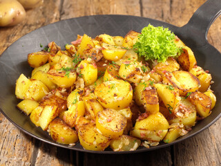 Wall Mural - Classic Roasted Potatoes in a Pan with Bacon and Onions on wooden Background