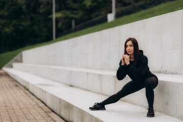 Wall Mural - Side view of young adult girl in sportswear and sneakers shoes warming up, jogging on cardio workout, spending day on sport training outdoor in city