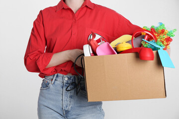 Wall Mural - Woman holding box of unwanted stuff on white background, closeup