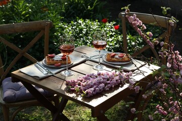 Canvas Print - Delicious Belgian waffles with fresh strawberries and wine served on table in spring garden