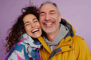 Wall Mural - Portrait of a joyful couple in their 40s wearing a functional windbreaker while standing against pastel purple background