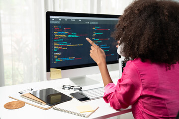 Wall Mural - Young working African woman creating coding website developer, thinking data information designer at home office, focusing on laptop Concept of analytical data center in java project job. Tastemaker.