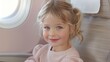 © chic designs - Smiling girl on a plane in the airport terminal happy ready to take a flight. Portrait of an excited cute Swedish little girl