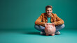 © ImageFlow - A cheerful man sitting with a piggy bank in front of a teal background, representing savings and financial planning.  Generative AI