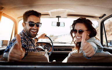 Canvas Print - Happy couple, thumbs up and car for travel, road trip and destination achievement with smile. Vehicle, transport and married people with hand gesture for journey goal, adventure or vacation location