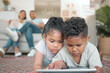 © peopleimages.com - Children, tablet and online for streaming movies or gaming on floor together in family home. Young boy, girl and technology with internet for mobile app, ebook and social media or reading on weekend