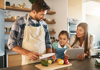 Family, nutrition and diet with people, tablet and ingredients for salad recipe on kitchen counter for dinner. Healthy, food and meal prep with cooking, together and bonding for clean eating in home