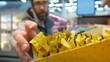 © Stockah - Close-up of many protein bars on the shelf of a supermarket and a male buyer reaching the hand to take one