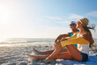 © ReadyAtTheEase/peopleimages.com - Couple, picnic and hug at beach with sunglasses, sunset and relax for vacation by ocean in summer. Man, woman and happy on sand in Miami with blue sky, view and partner on date for love or holiday