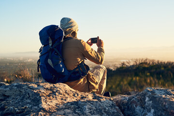 Canvas Print - Back, hiking and photograph with man in mountains for break, memory or scenic view of nature. Earth, phone camera and rest in summer with hiker person outdoor for adventure, fresh air or journey