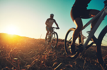 Sunset sky, people and friends on bicycle with fitness, race and adventure trail in nature together. Cycling, exercise and team with mountain bike in evening for outdoor workout, sun and countryside