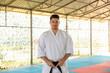 © New Africa - Karate coach wearing kimono and black belt at outdoor gym