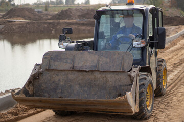 Construction equipment. Katlavan at the construction site. Tractor driving on sand.