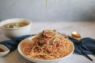 Wall Mural - Fried egg noodles in Thick Gravy with pork in white plate. Chinese food. Famous street food menu in Asia.