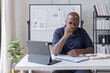 © Tj - Creative african businessman senior american worker using computer device in office,chat online, thinking business solution planning difficult decision pondering strategy come up with idea.
