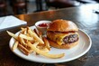 © EarthWalker - Burger, ketchup and French fries on white plate on restaurant table. Hamburger or cheeseburger and potato chips