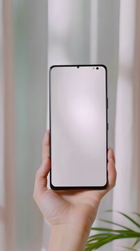 hand holding phone with blank white screen for mock up