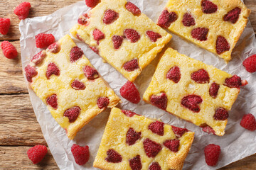 Poster - German open pie Raspberry Custard Kuchen or himbeerkuchen closeup on the paper on the wooden table. Horizontal top view from above