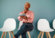 © peopleimages.com - Business woman, thinking and tablet in waiting room for recruitment ideas or job search goals. African worker on chair and digital tech with human resources for planning and career choice or decision