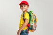 © gankevstock - Cheerful young boy with red cap and colorful backpack smiling brightly