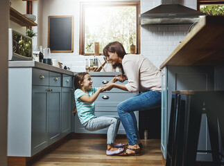 Canvas Print - Excited, daughter and woman with playing in kitchen for weekend fun, love and bonding in childhood. Care, smile and mom with little girl at family home for funny joke, humor and support in motherhood