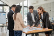© aekachai - Group of Asian businessmen discussed and presented graphs of business work. The team applauded to show goodwill in the conference room.