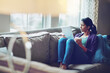 © ReadyAtTheEase/peopleimages.com - Coffee, thinking and girl with tablet on a sofa for calm, reflection and relax with social media, streaming or service at home. Digital, memory and woman person with tea a in living room with ebook