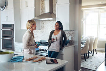 Wall Mural - Coffee, morning and relax with friends in kitchen of home together for bonding or breakfast. Conversation, smile and women with happy roommate people drinking tea in apartment for break or chatting