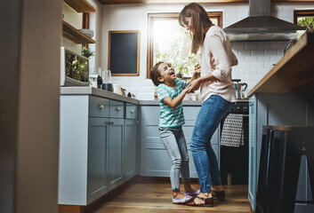 Wall Mural - Dancing, energy and mother with child in kitchen for bonding, fun and listening to music together. Smile, excited and mom teaching girl kid to groove to radio, playlist or song at home in Canada.