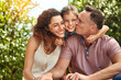 © peopleimages.com - Family, happy and child hug outdoor with bonding, care or support for security trust together in backyard. Smile, woman and man or kid embrace moment, love and sunshine vacation of childhood memory
