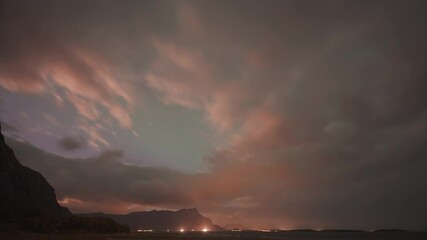 Wall Mural - Vibrant display of aurora borealis lights up the clouds and dances in the sunset sky