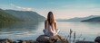 © Ilgun - A woman is seen meditating on a hill overlooking the sea in a peaceful setting, with a view from behind, providing ample space for adding text to the image.