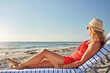 © ReadyAtTheEase/peopleimages.com - Holiday, woman and relax with chair at beach for travel, tropical vacation and outdoor adventure. Peace, female person and tourist with thinking by ocean for summer, getaway and weekend trip in Bali