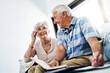 © ReadyAtTheEase/peopleimages.com - Senior couple, home and happy with writing on document in sofa for grocery or shopping list for household. People, planning and budgeting, saving and notebook for insurance and asset management
