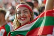 © ChaoticMind - Energetic young female fan with face paint and draped in Hungarian flag excited at a game