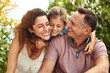 © peopleimages.com - Happy, family and child hug outdoor with bonding, care or support for security trust together in backyard. Smile, woman and man or kid embrace moment, love and sunshine vacation of childhood memory