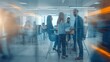 © Premium_art - Blurred view of busy office space with people working and collaborating.