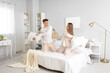 © Pixel-Shot - Happy young couple fighting pillows in bedroom