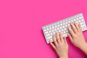 Wall Mural - Female hands typing on keyboard on pink background