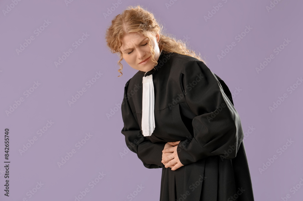 Female judge suffering from menstrual cramps on violet background