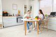 © Pixel-Shot - Young couple cooking vegetables at table in kitchen