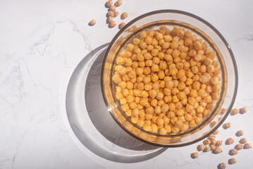 Wall Mural - chickpea soaked in water in a glass bowl on marble table.
