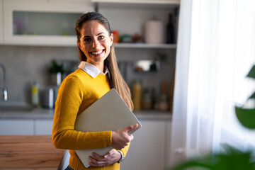 Wall Mural - Portrait of a smiling confident businesswoman with laptop in a home office.