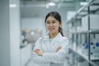 © dreamdes - Asian female scientist in lab coat with arms crossed in laboratory. Science and research concept. Medicine and health care. Portrait of young woman researcher in bright lab