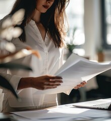 Poster - A businesswoman at a desk and reads a document.