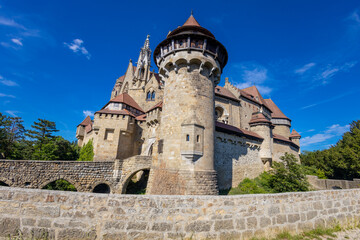 Castle landmark under blue sky. Medieval castle in Austria. Ancient historical sights around Vienna. Castle Kreuzenstein old building from outside