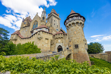 Castle landmark under blue sky. Medieval castle in Austria. Ancient historical sights around Vienna. Castle Kreuzenstein old building from outside