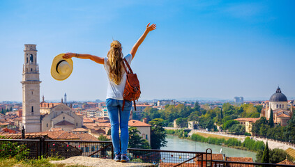 Wall Mural - Happy traveler girl in Verona- panoramic view of cityscape in Italy